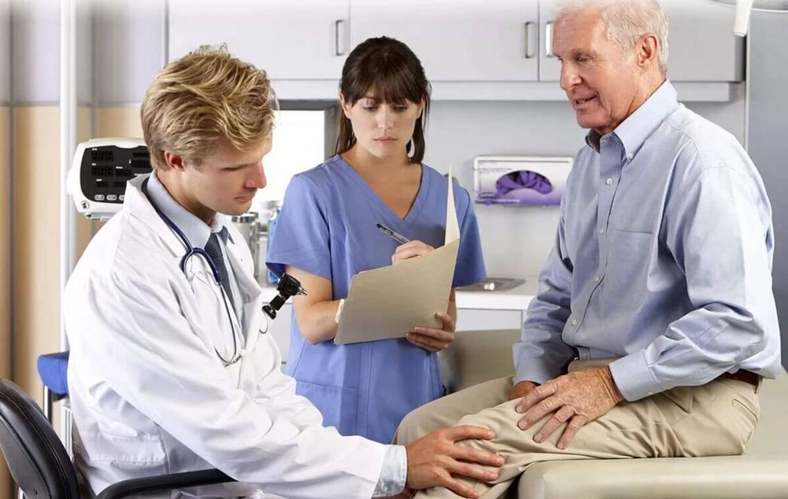 Ein älterer Mann mit einer Arthrose des Knies in einem Termin mit dem Arzt